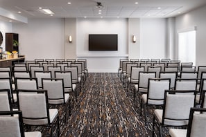 A conference room with rows of chairs, a large screen, and a projector. - Hyatt Place at Anaheim Resort/Convention Center (Anaheim)