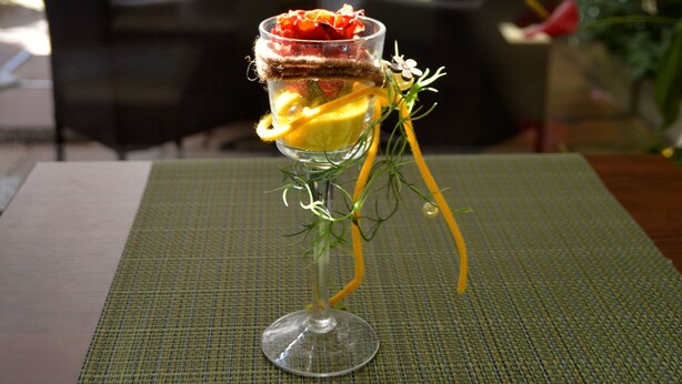 A dessert in a glass on a table with a green placemat, with a view of a restaurant named "Aren City" in the background. - Hotel Arena City (Leipzig)