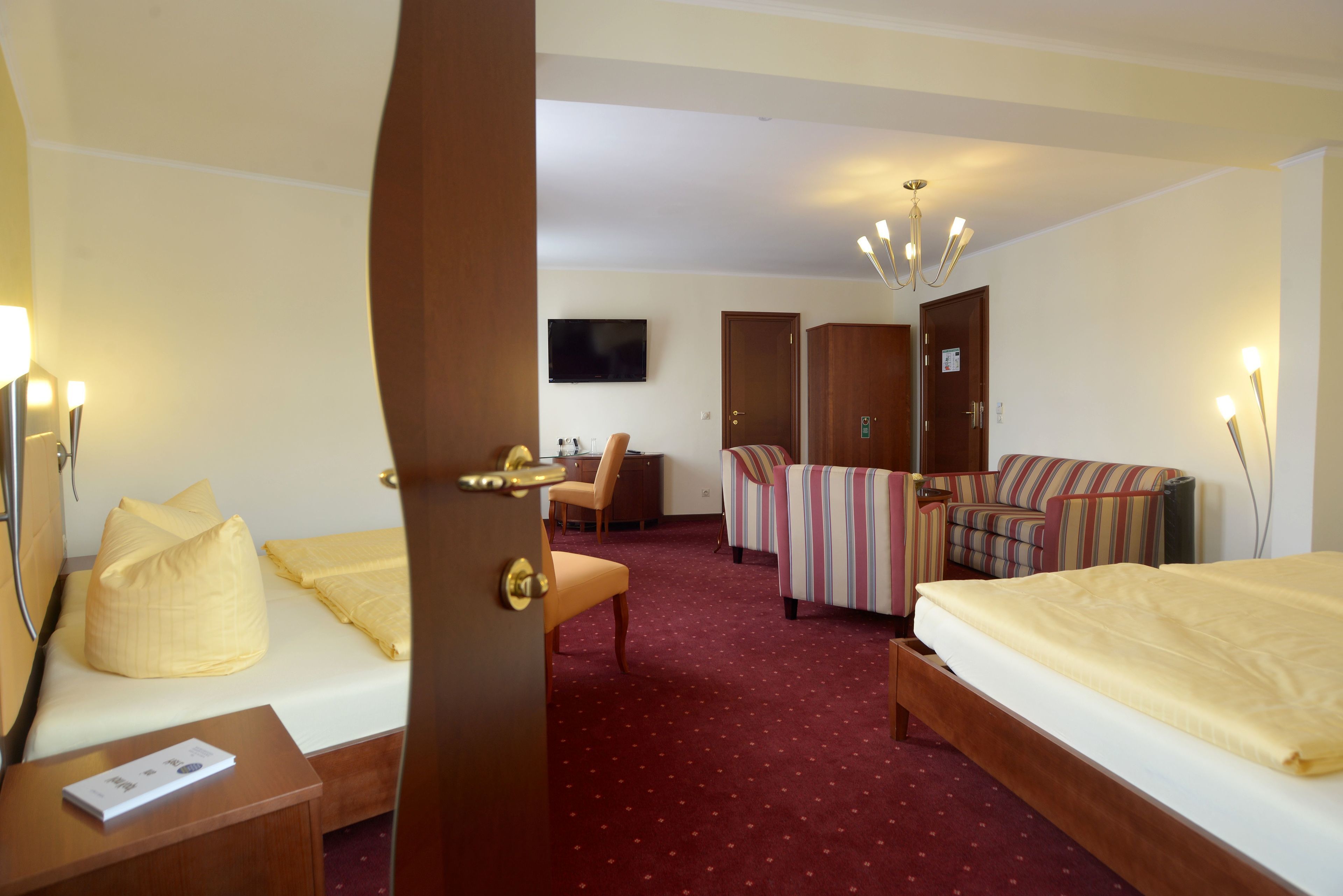 Une chambre d’hôtel avec deux lits, un bureau, une chaise et un canapé.