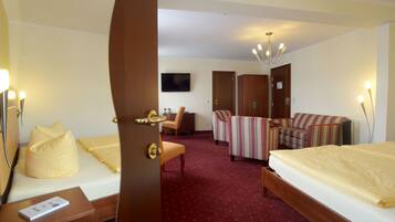 Une chambre d’hôtel avec deux lits, un bureau, une chaise et un canapé.