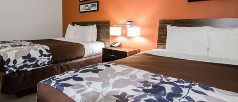 Een hotelkamer met twee bedden, een nachtkastje en een wandlamp.