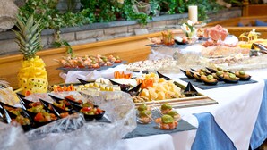 Una mesa de buffet con diversas opciones de comida y una piña como centro de mesa.