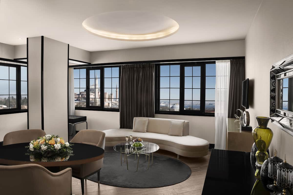 Una sala de estar moderna con un sofá, una mesa de centro redonda y un comedor con una mesa y sillas.