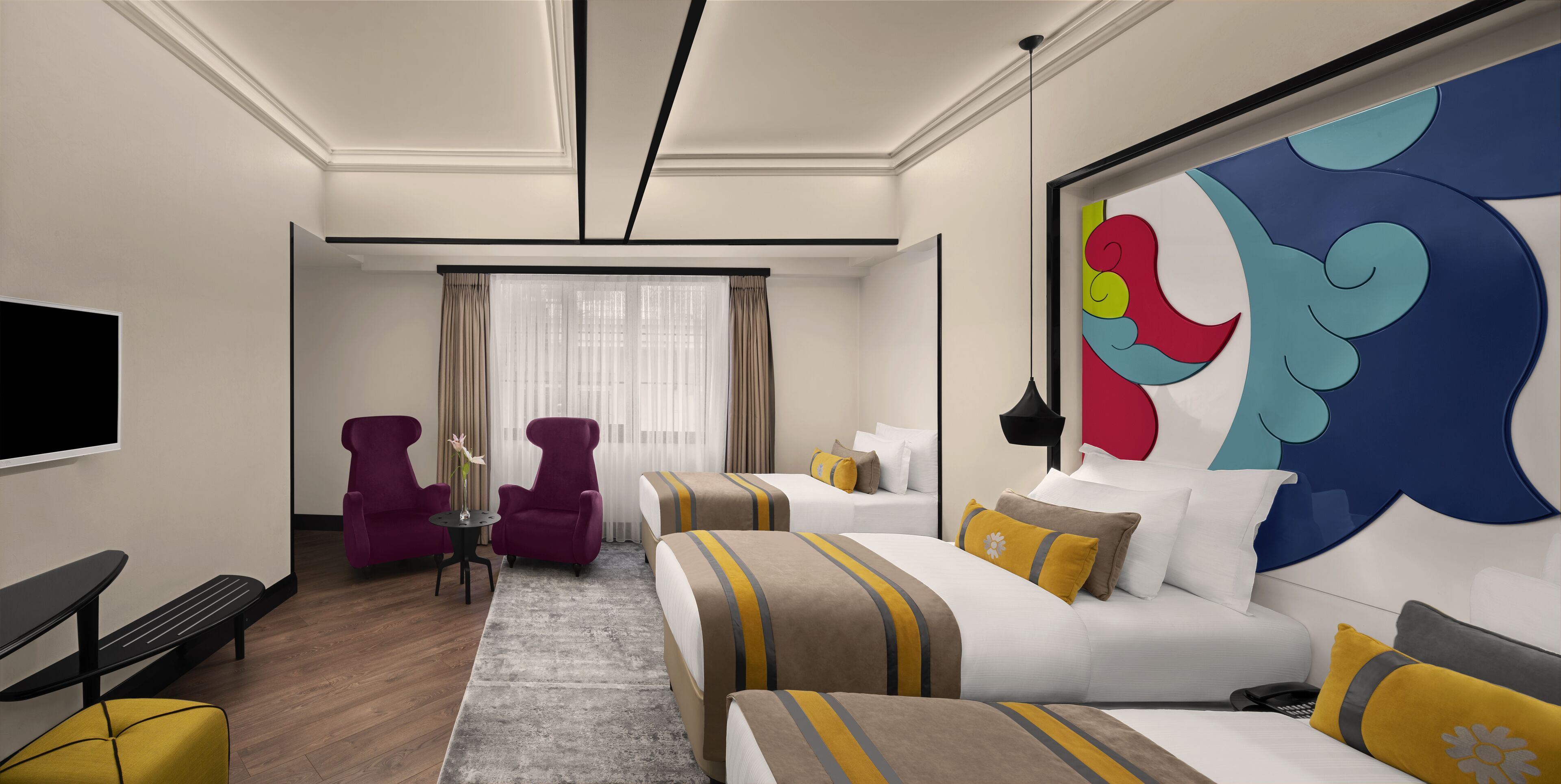 A hotel room with a bed, two armchairs, a small table with a vase, a large abstract painting, and a TV.