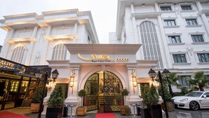 Hagia Sophia Hotel's indgang med rød løber, dekorative porte og en hvid bygningsfacade.