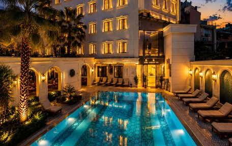 A hotel with a swimming pool, multiple balconies, and a spa area.