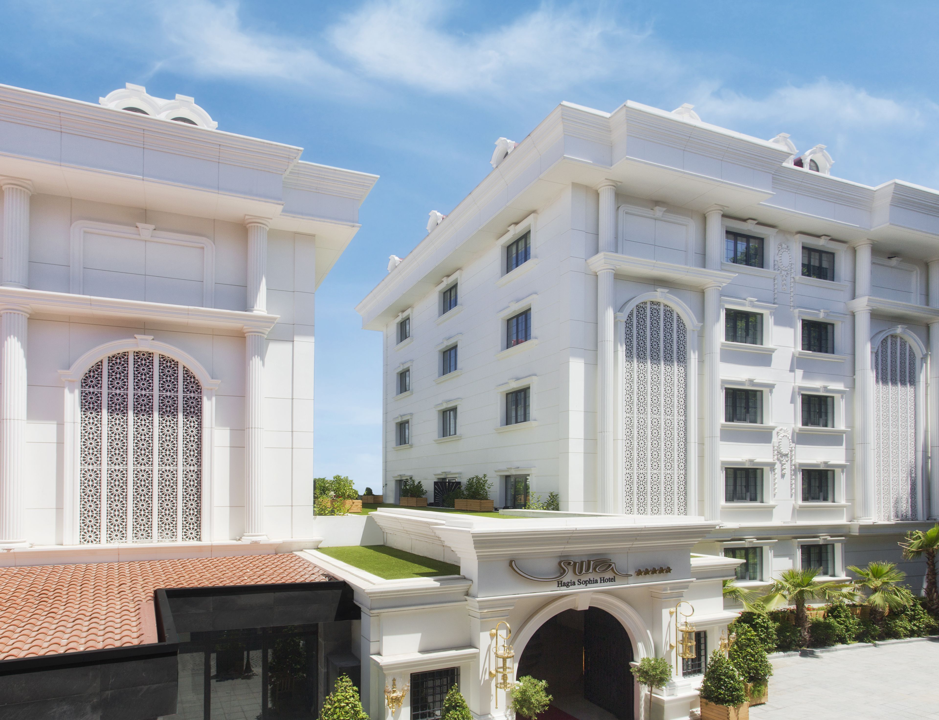 A white building with a central entrance, large windows, and a sign reading "Hagia Sophia Hotel".