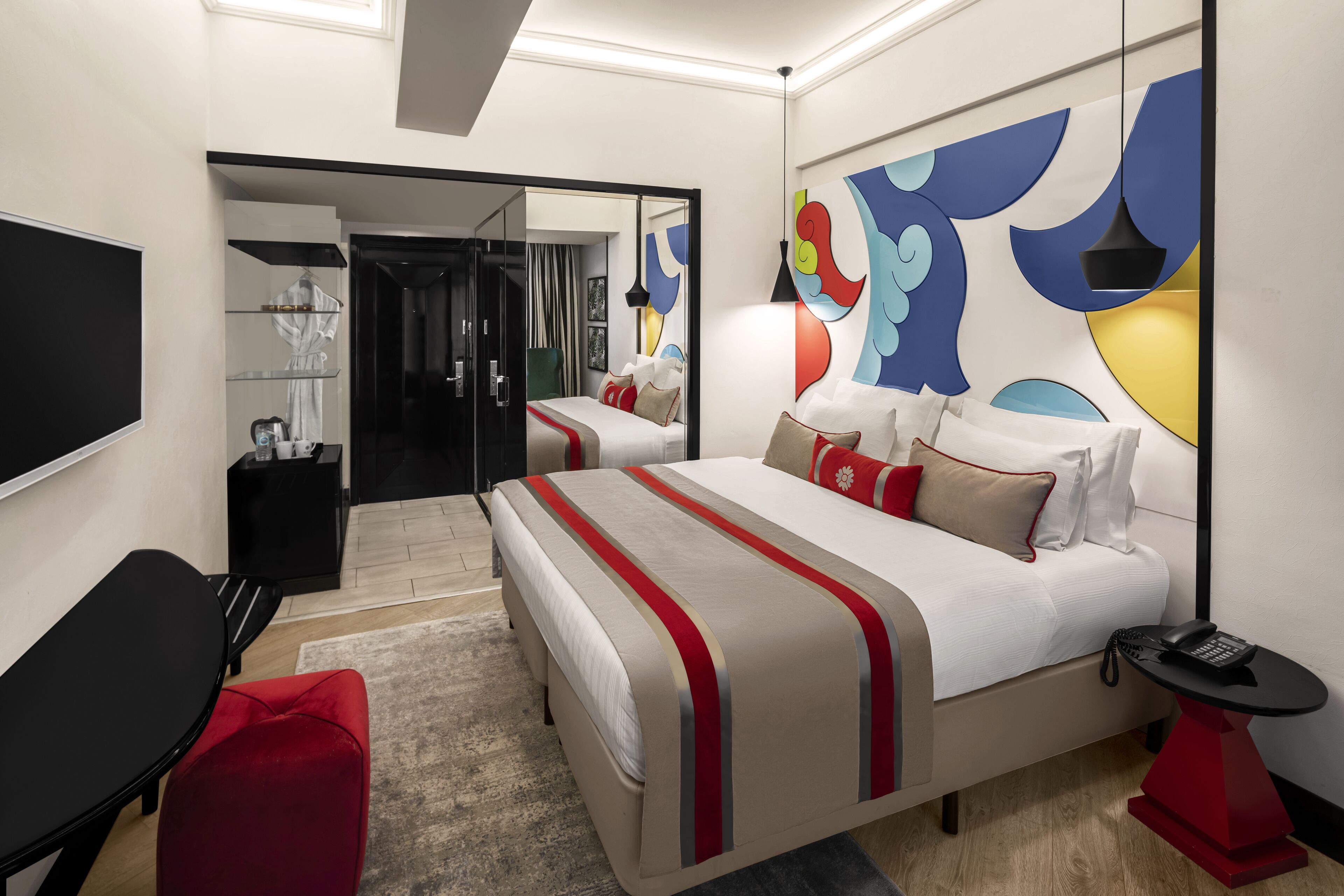 Une chambre d’hôtel moderne avec un grand lit, un bureau et un miroir.