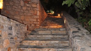A stone staircase leading up a hill, surrounded by foliage and stone walls. - Petrino (Naxos)