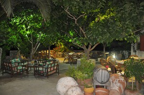 An outdoor seating area with wooden furniture and potted plants. - Petrino (Naxos)