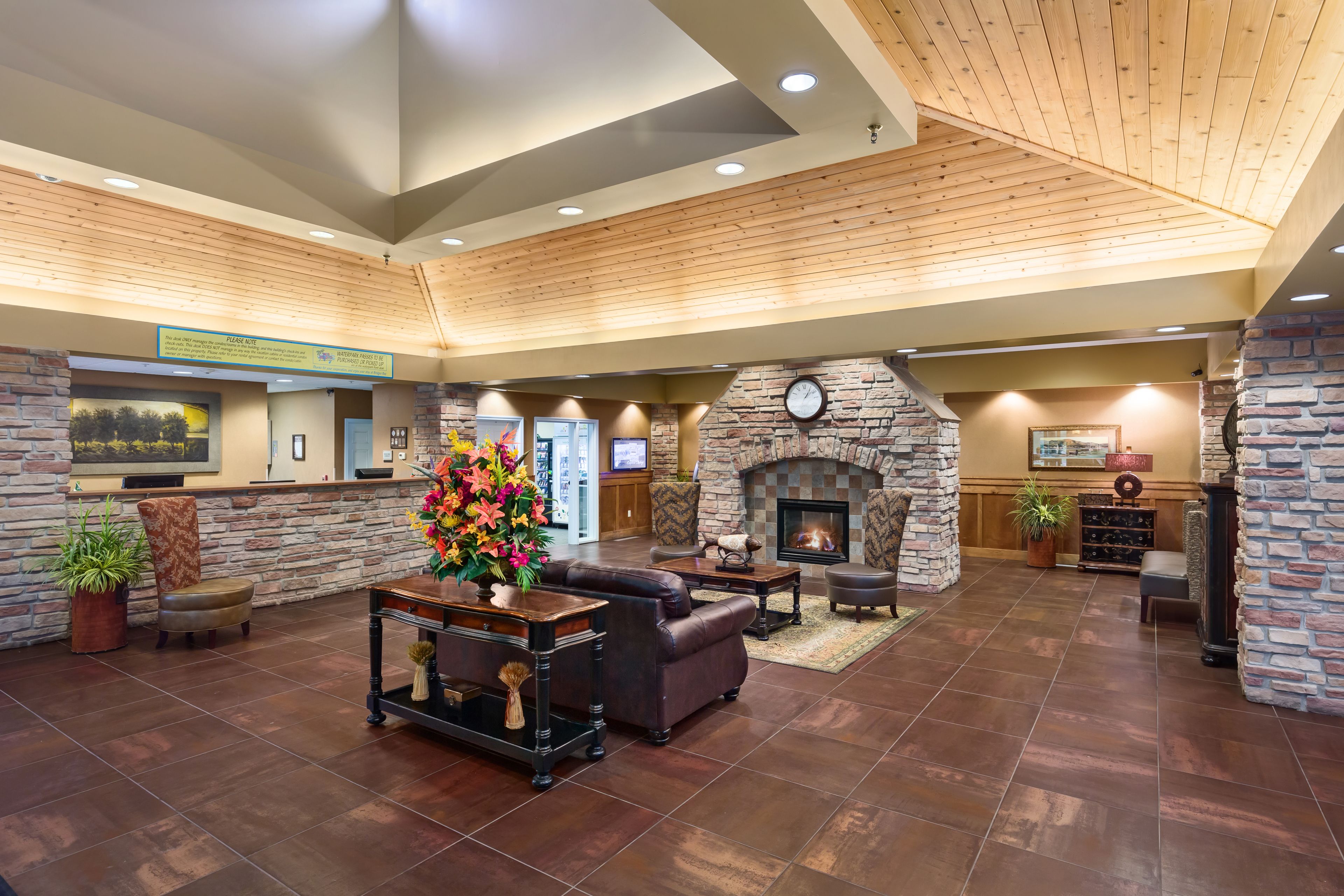 A spacious lobby with a fireplace, leather seating, and a reception desk.