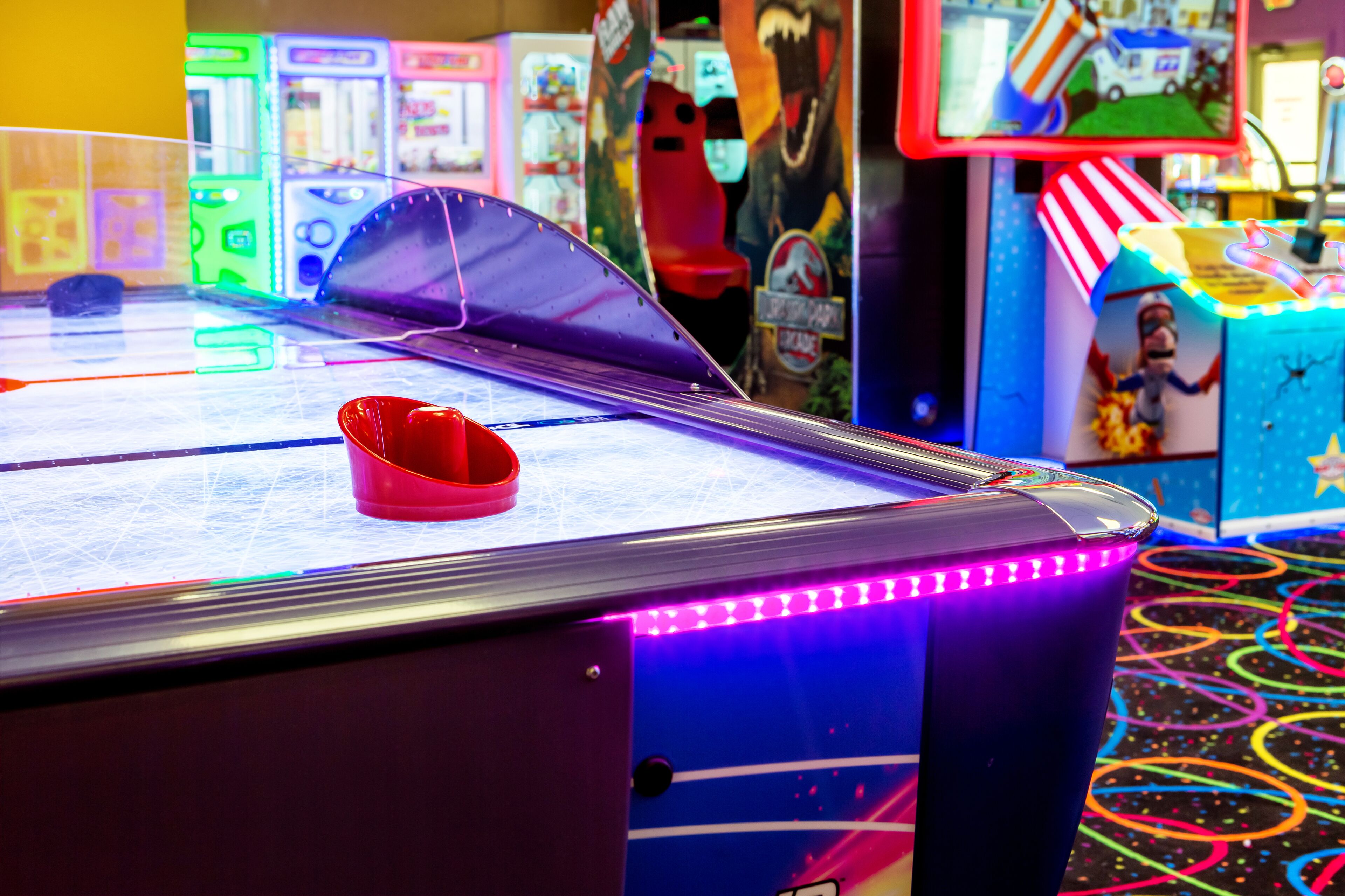 Un salón recreativo con varios juegos, incluyendo una mesa de tenis de mesa y una paleta roja.