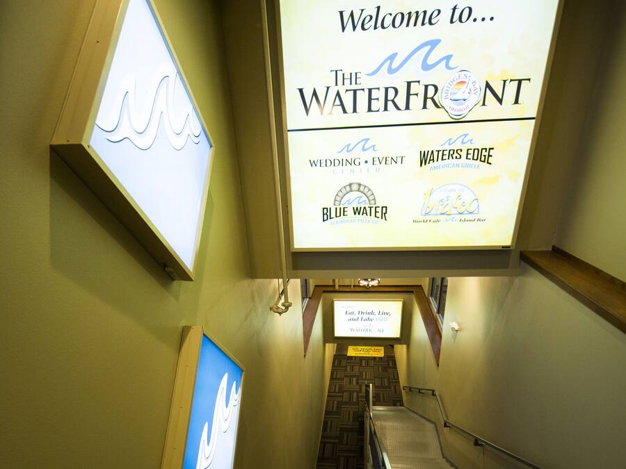 En trappa leder upp till ett receptionsområde med en stor välkomstskylt för evenemanget ”The Waterfront”.