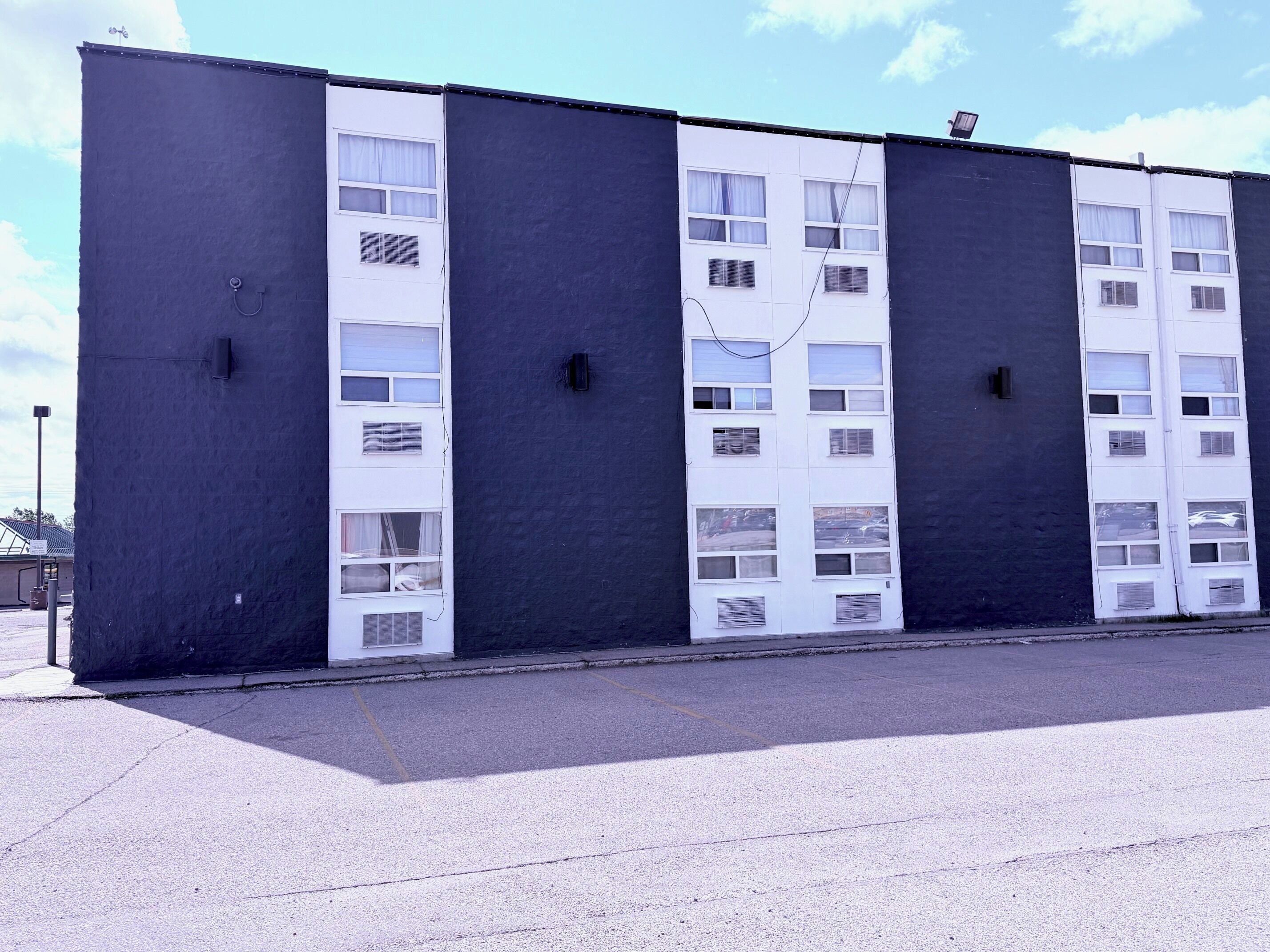 Un gran edificio industrial con múltiples puertas y ventanas blancas, techo plano y suelo de concreto.