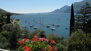 Une vue côtière avec des bateaux sur l’eau, entourée de verdure et de montagnes.