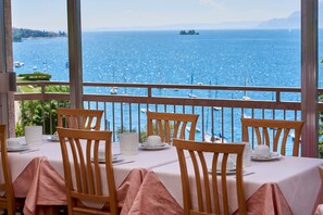 Mesa para cuatro con vista al mar y barcos.