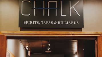 A bar named Chalk with a sign indicating it offers spirits, tapas, and billiards.