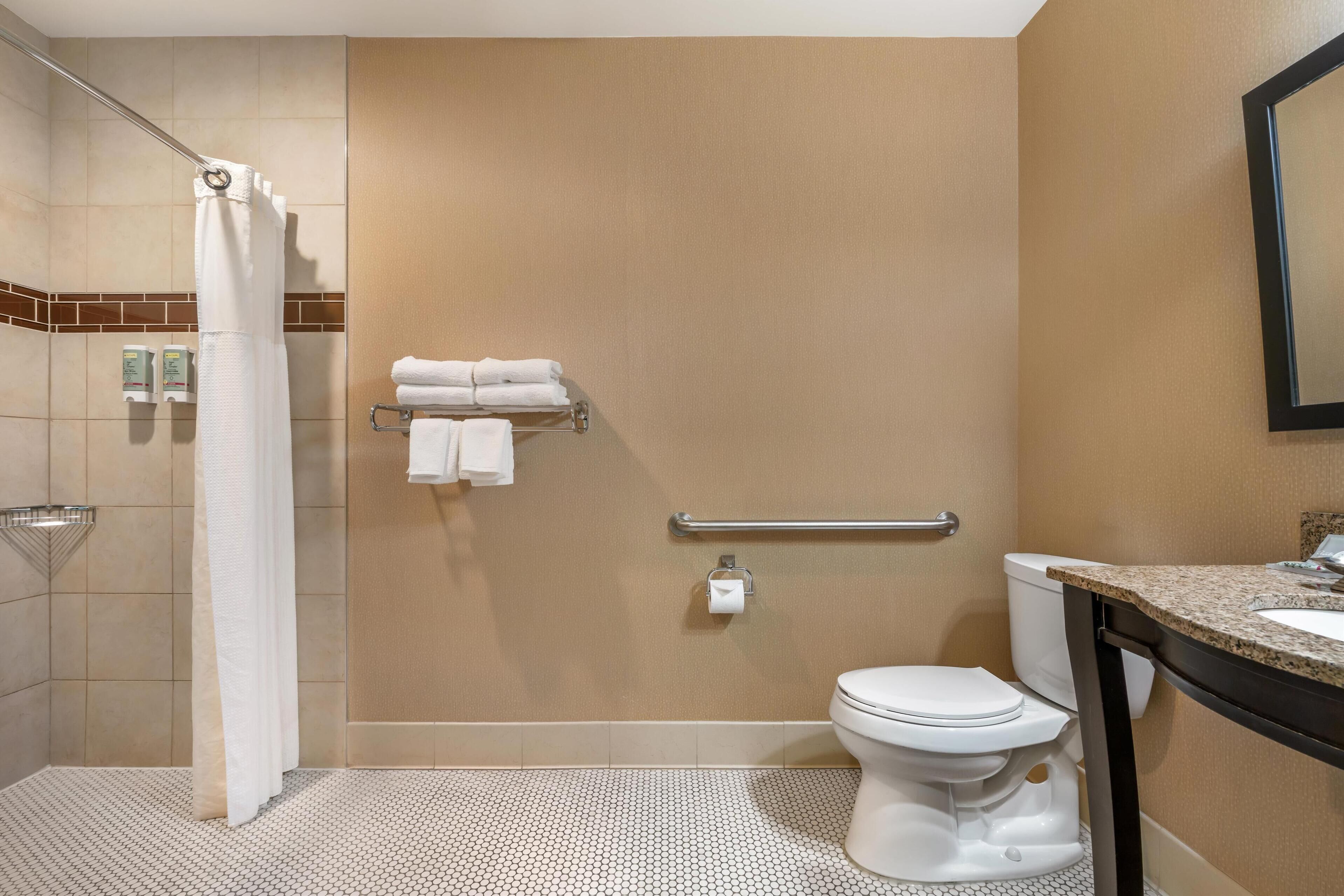 A bathroom with a shower, toilet, and sink.