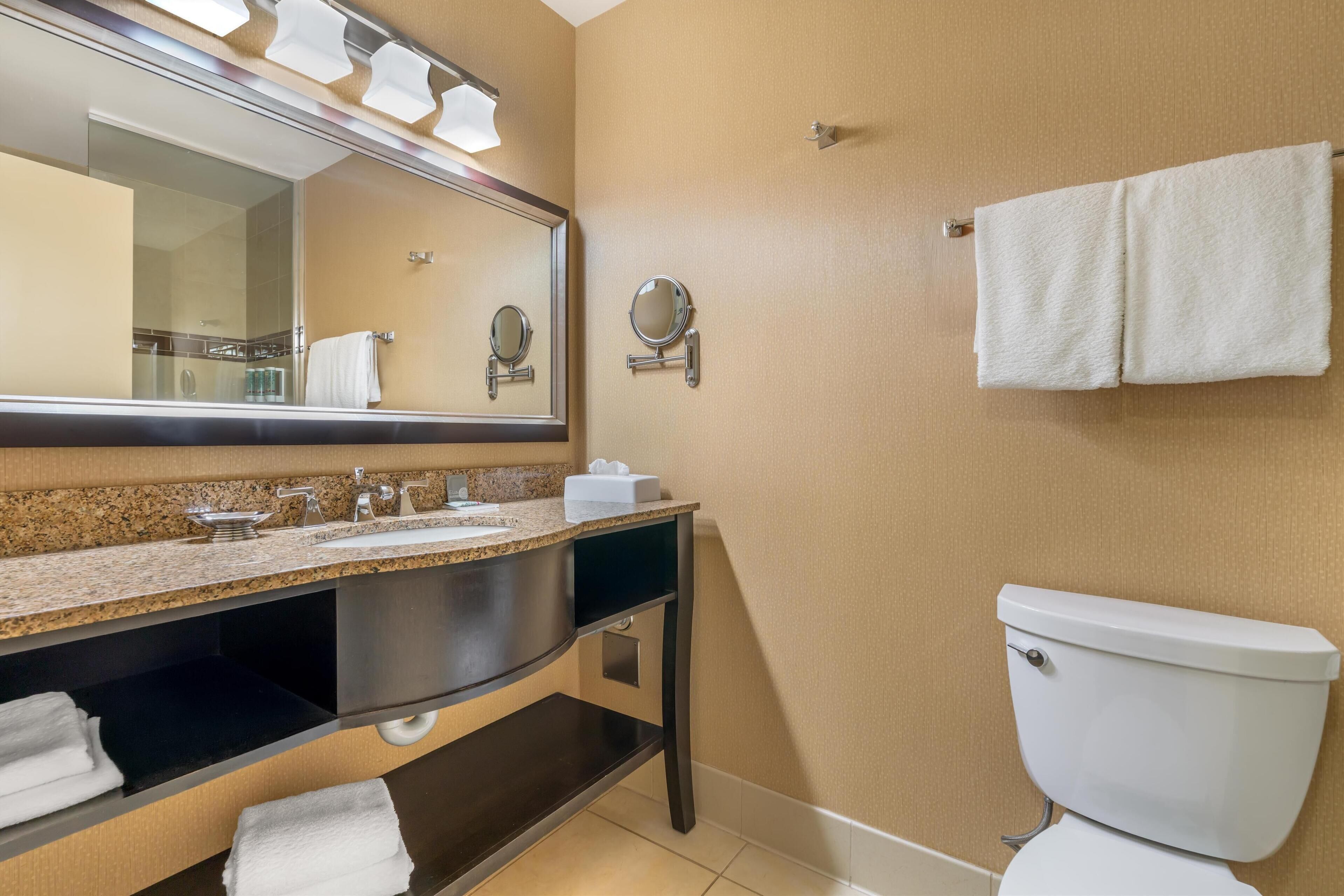 A bathroom with a sink, mirror, towel rack, and toilet.