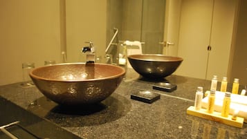 Un baño con dos lavamanos de cerámica grandes, un espejo y un soporte para dispensador de jabón.