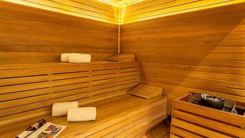 A sauna with wooden benches, a bench with a towel, and a sauna tub.