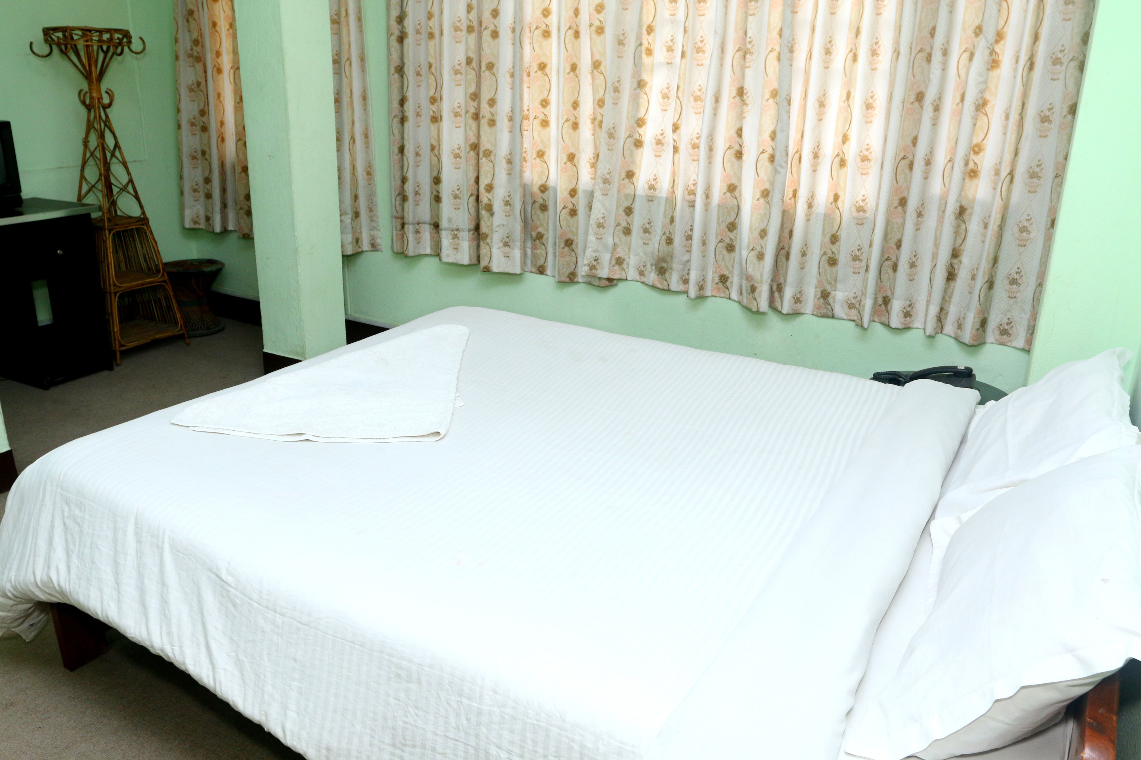 A room with a single bed, a small desk, and a chair.