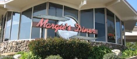 A building with a sign that reads "Morgie's Diner" and a large glass window.