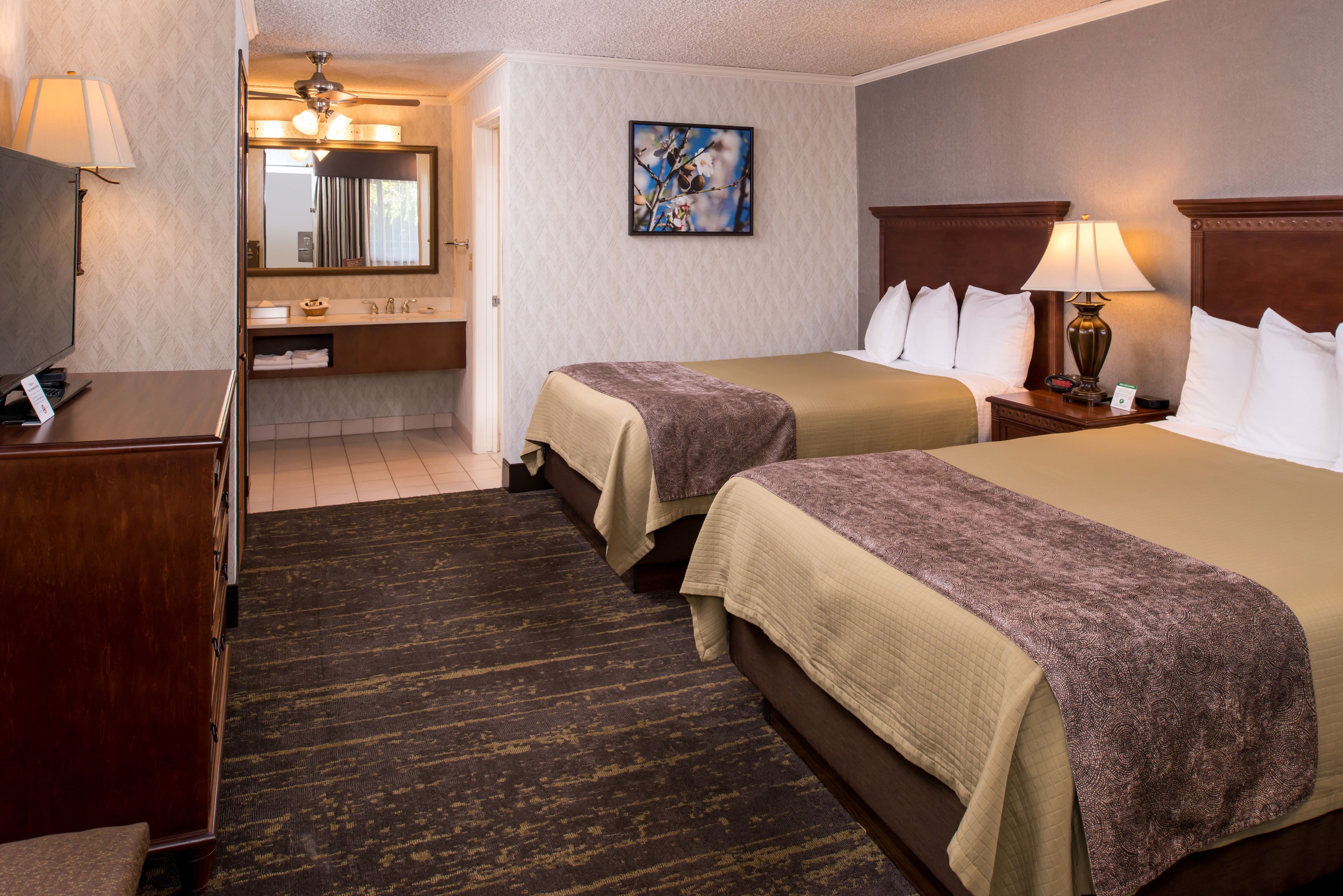 Une chambre d’hôtel avec deux lits, une salle de bain et un bureau.