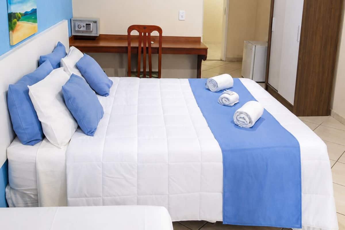 Ein Hotelzimmer mit Bett, Schreibtisch, Stuhl und Kleiderschrank.