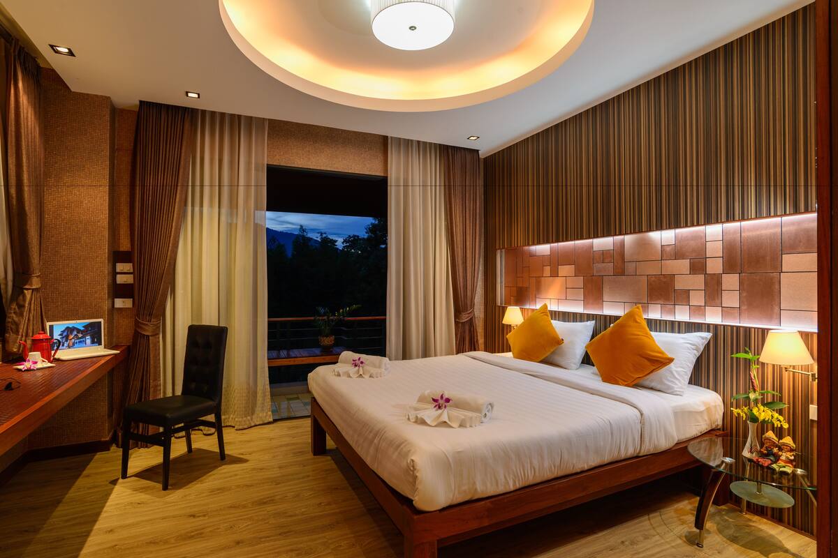 Una habitación de hotel con cama, escritorio, silla y vistas al exterior.