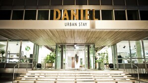The entrance to the Daniel Urban Stay hotel with a modern design, featuring a wooden facade and glass doors. - Hotel Daniel Vienna (Vienna)