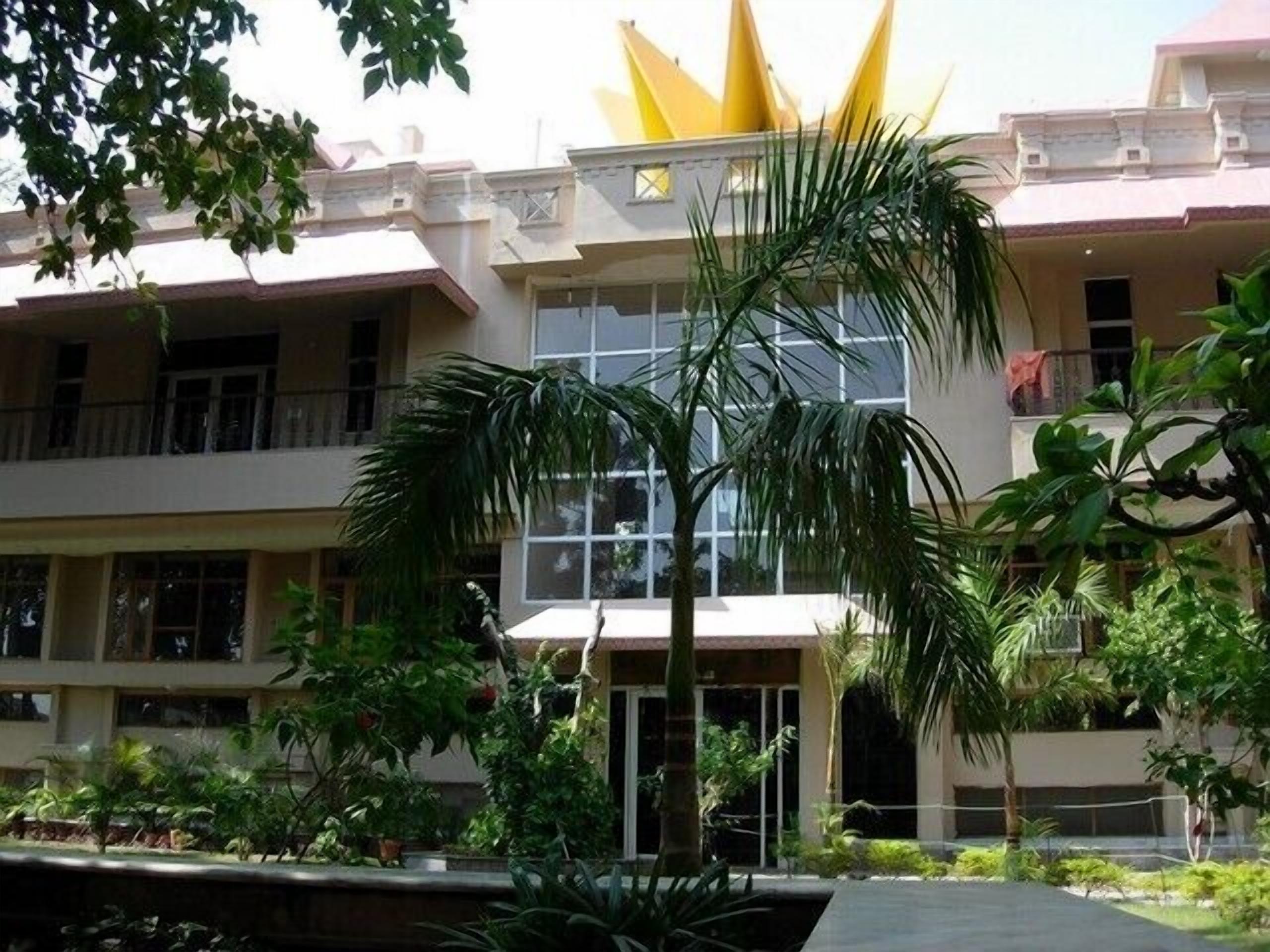 A multi-story building with balconies, large windows, and a central entrance.