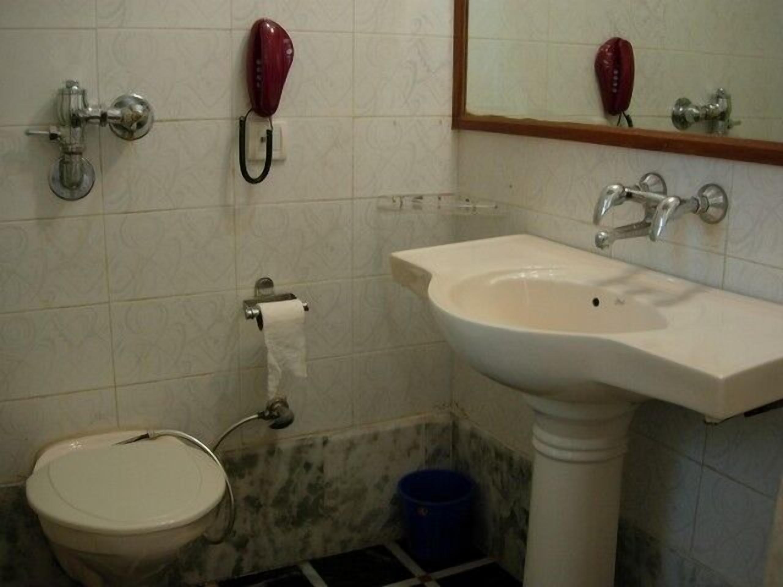 A bathroom with a toilet, sink, and two red telephone booths.