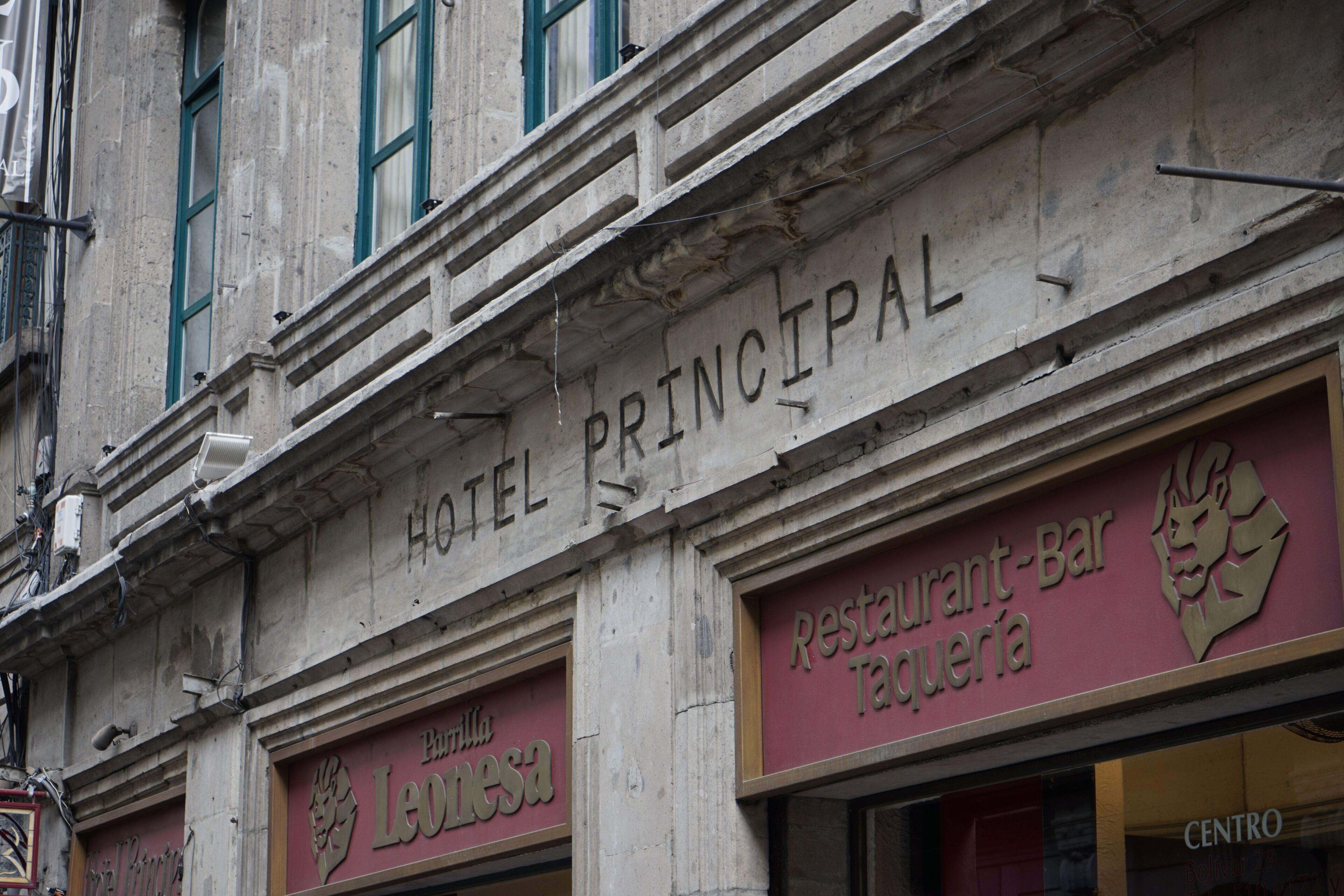 Hotel Principal with signs for 'Parilla Leonesa' and 'Restaurante-Bar Taquería'.