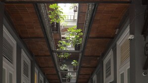 A corridor with a tiled floor, a brick ceiling, and a series of doors on either side. - Hotel Principal (Mexico City)