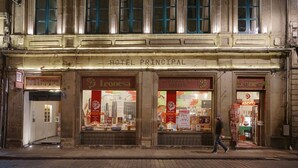 A multi-story building with a sign reading "Hotel Principal" and several storefronts below, including a restaurant and a bar. - Hotel Principal (Mexico City)