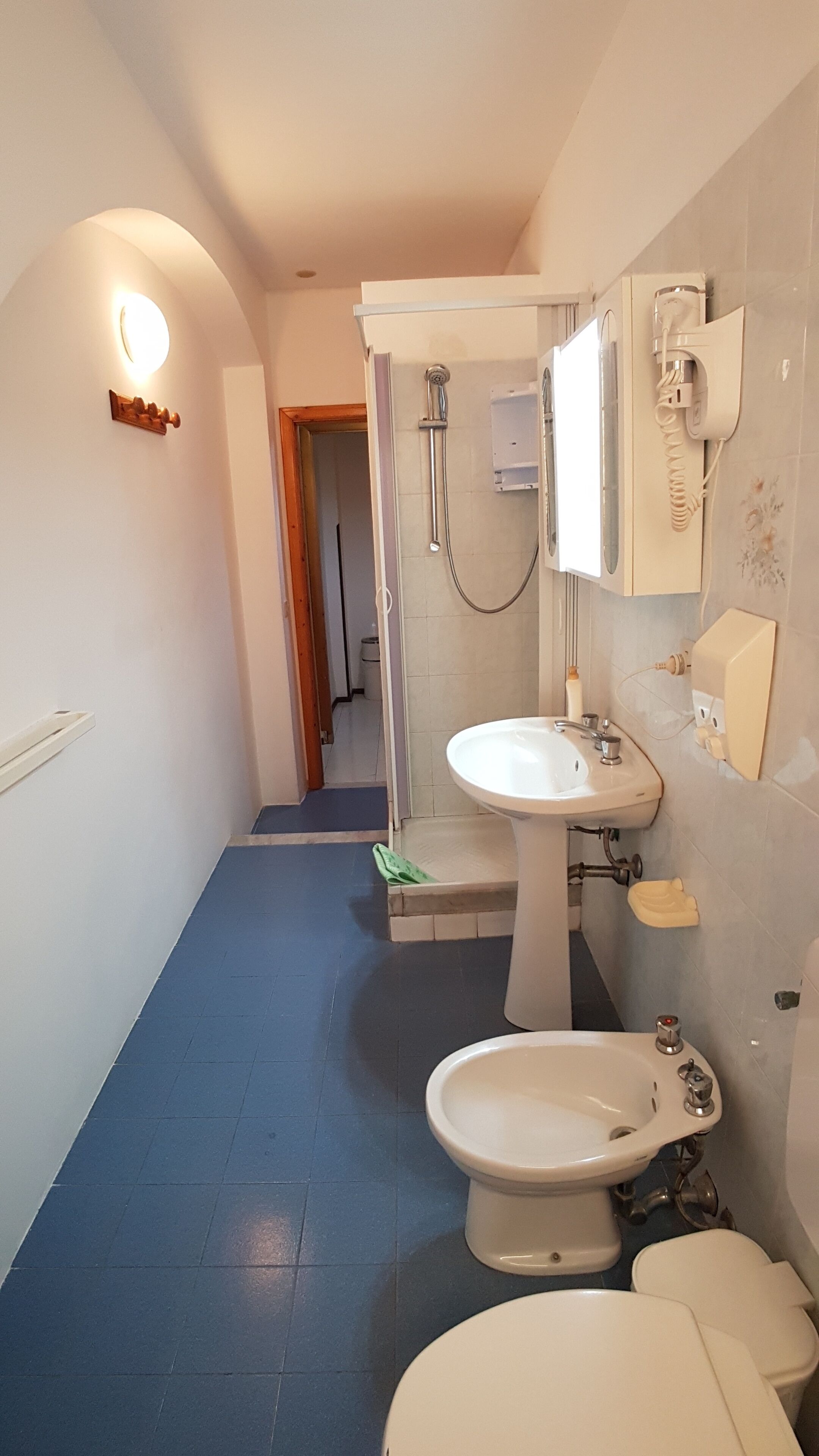 A bathroom with a toilet, bidet, and sink.