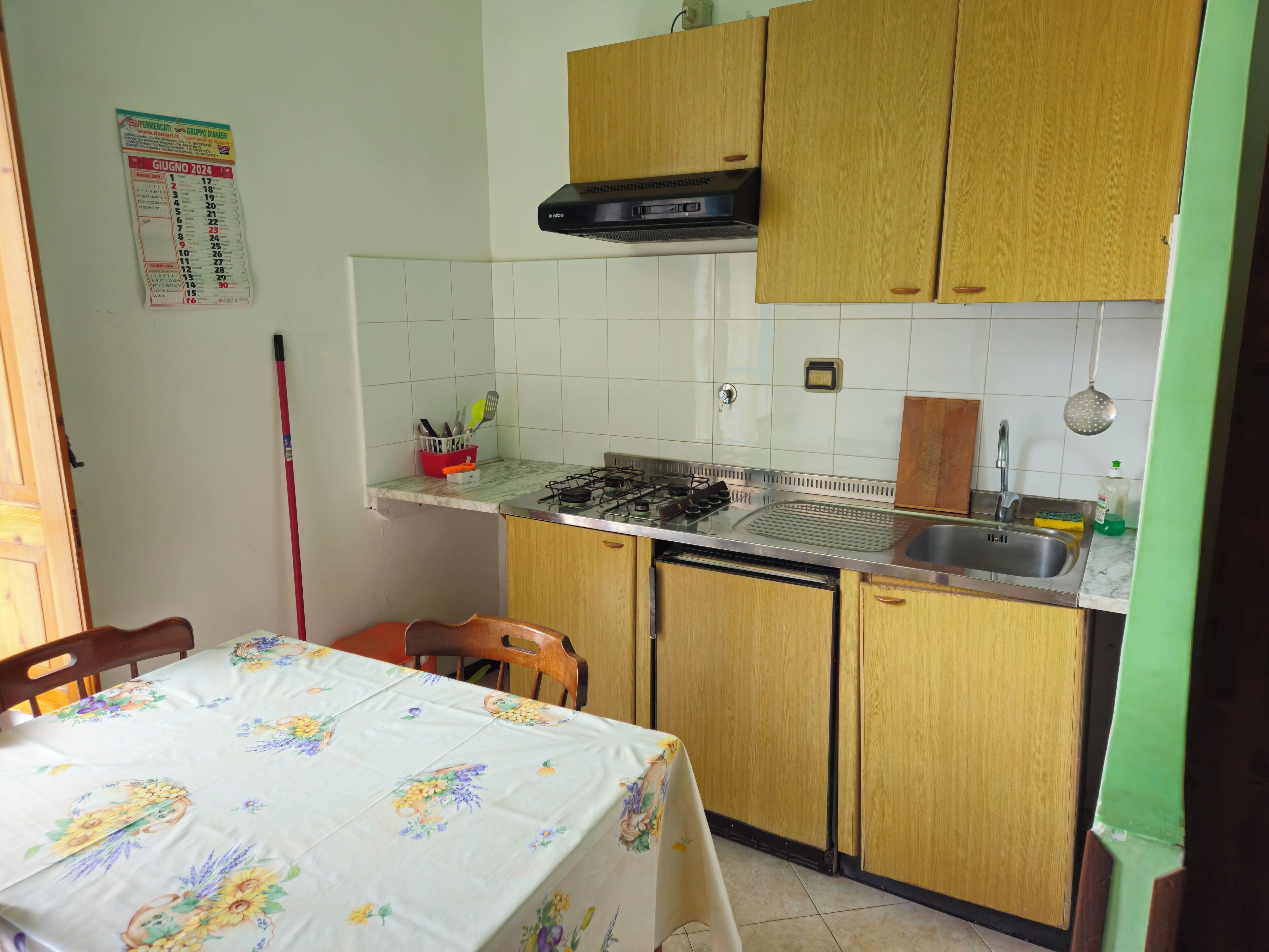 A compact kitchen with wooden cabinets, a gas stove, and a sink.