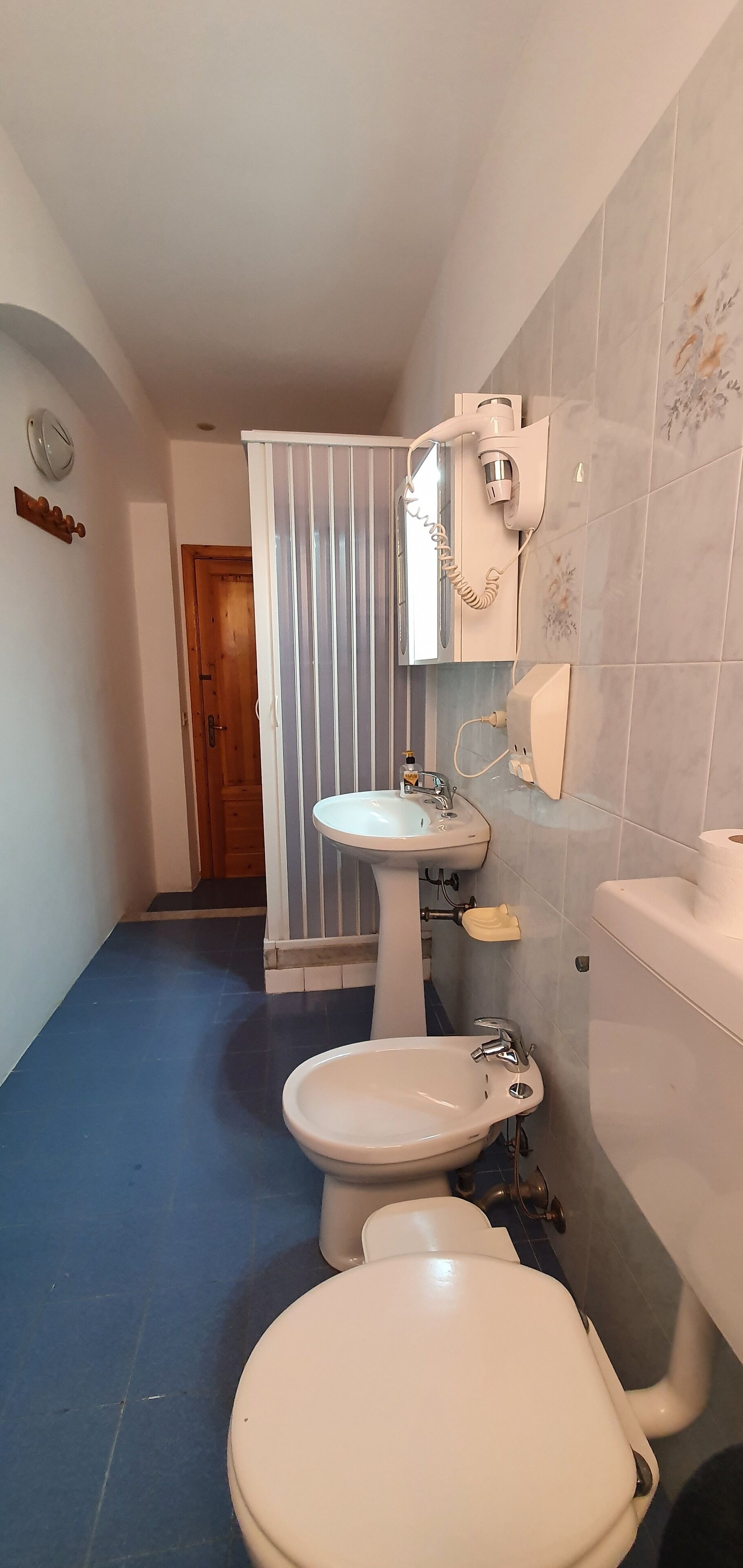 Un baño con inodoro, lavamanos y ducha.