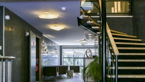 Un intérieur moderne avec une moquette violette, un escalier et une mezzanine.