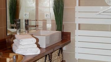 Un bagno con un grande specchio, un lavandino bianco e un porta asciugamani.