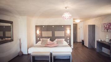 A modern bedroom with a large bed, bedside tables, a mirror, and a hanging light fixture.