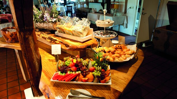 A buffet with various food items and a knife and fork on a plate. - Benniksgaard Bed & Breakfast (Grasten)