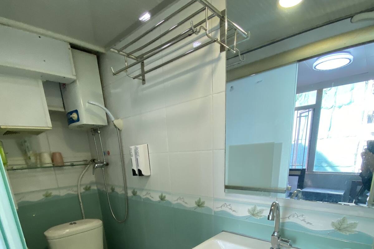 A bathroom with a toilet, sink, and shower.