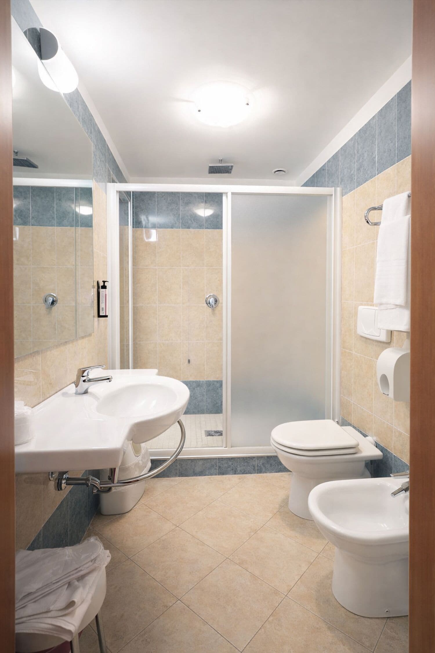 Un baño moderno con ducha, dos lavamanos, inodoro y bidé.