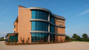 A modern hotel building with a curved facade, large windows, and a sign that reads "HOTEL RIZ". - LVG Hotel Collection – Riz (San Genesio ed Uniti)
