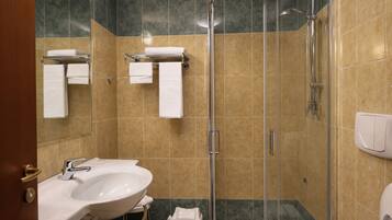 Un baño con ducha, lavabo e inodoro.