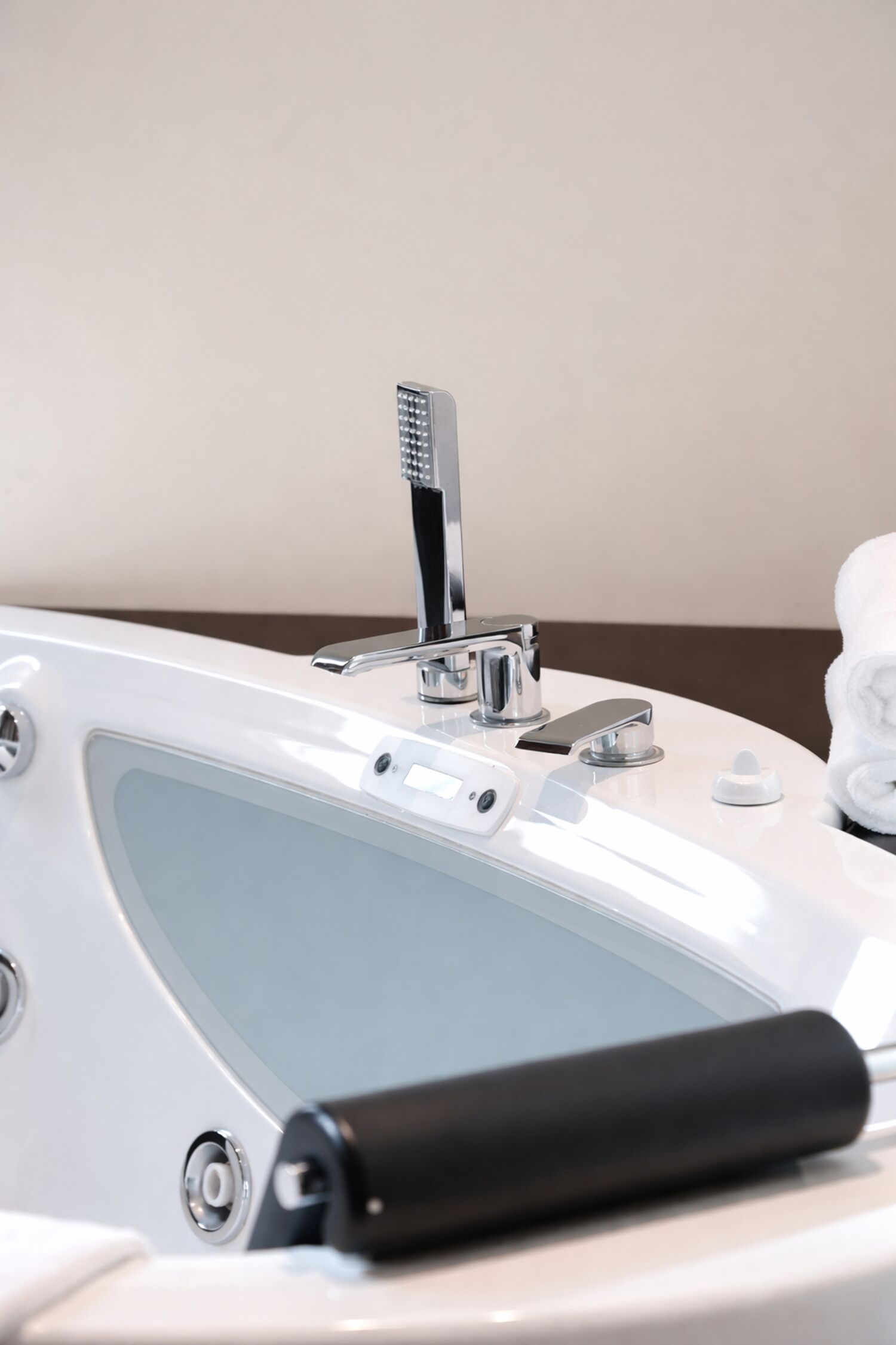 A modern bathroom with a bathtub, a handheld showerhead, and a towel rack.