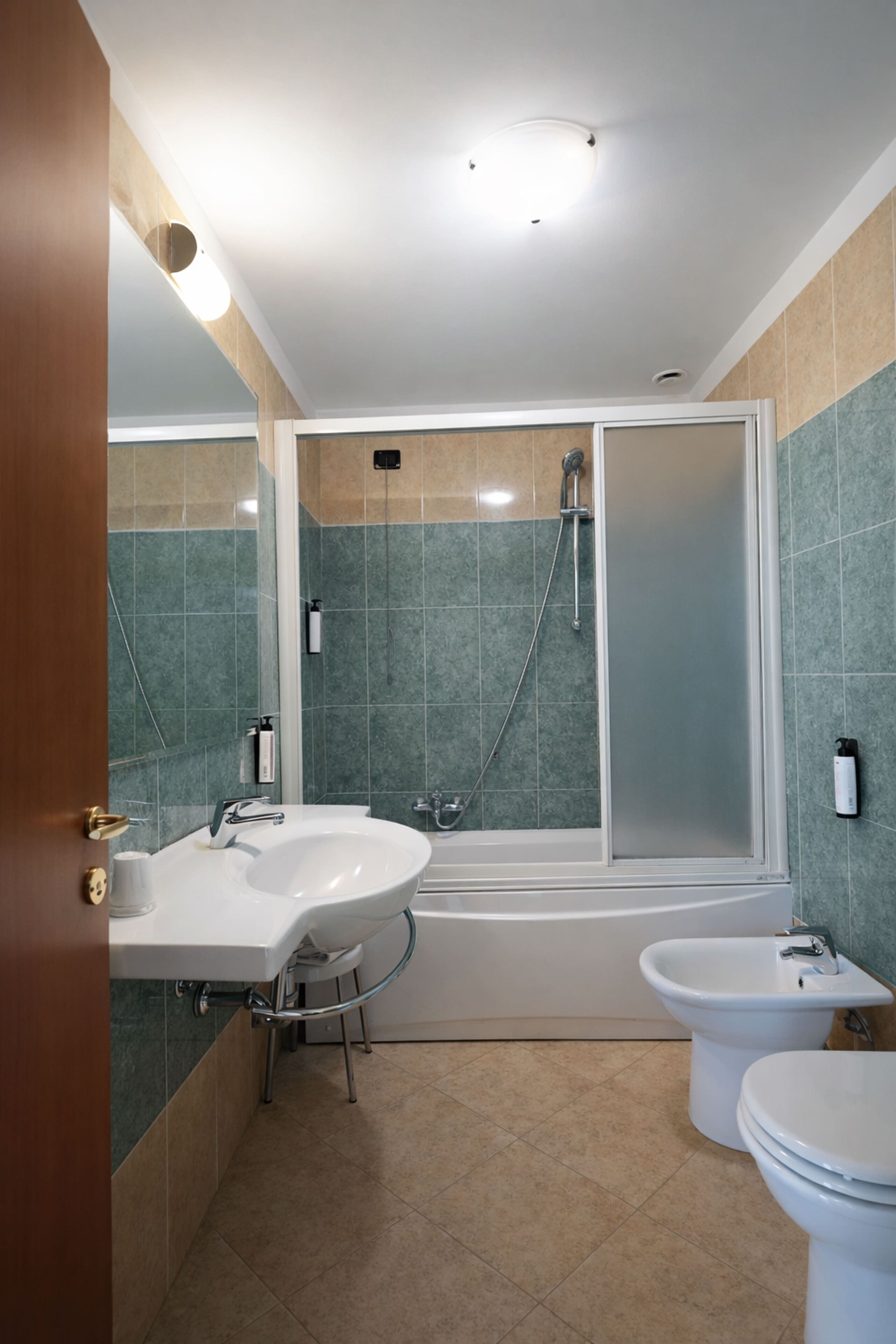 A modern bathroom with a bathtub, two sinks, and a toilet.