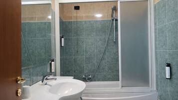 A modern bathroom with a bathtub, two sinks, and a toilet.